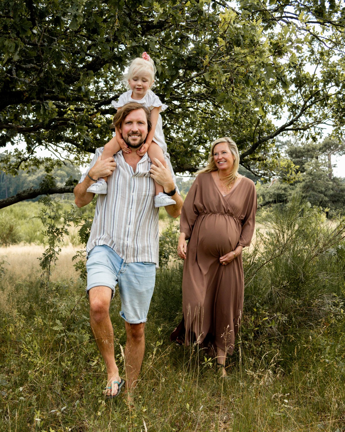 Gezin tijdens een zwangerschapsshoot in de natuur